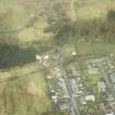 Oblique aerial view centred on station and level crossing site and the NW end of Langholm Street, taken from the SE.