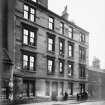 View of 40 Reid Street, Bridgeton, Glasgow, with women standing in front of houses.
Titled below: '12 Dwellings, in all, 33 apartments. 16 Taps, 4 W.Cs.'
