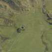 Oblique aerial view centred on the chapel and burial ground with the remains of the dun adjacent, taken from the NW.