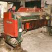 Interior. Tanyard. Preparation of hides prior to tanning. View of Fleshing Machine which removes fat and tissue from the underside of the hide. Fleshing also helps to 'relax' the skins and removes other remaining hair and roots from the uppermost surface of the hide. Note the fleshings flowing out the bottom of the machine.