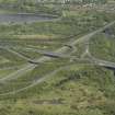 Oblique aerial view centred on the motorway interchange, taken from the NW.