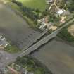 Oblique aerial view centred on the old bridge, rail bridge and new road bridge, taken from the SW.