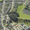 Oblique aerial view centred on the water tower with the high school adjacent, taken from the NE.