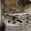 Interior. First floor. View of grinding stones, wooden frame (or horse) and hopper.