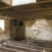 Interior. First floor, storage area from milling floor . Note sack hoist frame in floor joists and shute openings into the kiln floor.