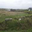 General view looking towards mill building with embanment of dam in foreground. Note up-ended flagstones forming kerb.