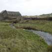 View of mill building , lade and stream from mill pond in foreground.