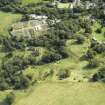 Oblique aerial view centred on the house and walled garden with the earthwork adjacent, taken from the NNW.