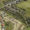 Oblique aerial view centred on the remains of the station with the station house adjacent, taken from the NW.