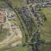 Oblique aerial view centred on the remains of the station with the station house adjacent, taken from the W.