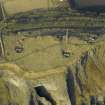 Oblique aerial view centred on the remains of the battery with Macduff's cave in the foreground, taken from the SSE.