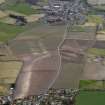 General oblique aerial view centred on the field boundaries with the town and village adjacent, taken from the E.