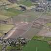 General oblique aerial view centred on the field boundaries with the town and village adjacent, taken from the ENE.