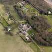 Oblique aerial view centred on the home farm with the cottages, houses and walled garden and orangery adjacent, taken from the W.