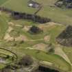 Oblique aerial view centred on the golf course with the country house, dovecot and lodge adjacent, taken from the NW.