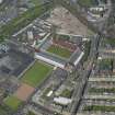 Oblique aerial view centred on the football stadium with the distillery adjacent, taken from the SW.