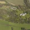 General oblique aerial view centred on the house with the stable block adjacent, taken from the S.