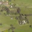 Oblique aerial view centred on the remains of the house with the remains of the stables adjacent, taken from the S.