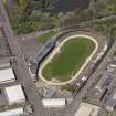 Oblique aerial view centred on the greyhound stadium, taken from the SSE.