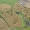 Oblique aerial view of the cropmarks of the pits, rig and furrow and field boundaries, taken from the SW.