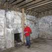 Clais Charnach, store house, interior view. Mr Ian Parker (RCAHMS) in picture.