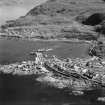 Oblique aerial view of Mallaig centred on the town and station with the harbour adjacent.