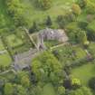 Oblique aerial view of the tower house with the gardens and stables adjacent, taken from the WNW.