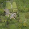 Oblique aerial view of the tower house with the gardens and stables adjacent, taken from the S.