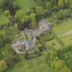Oblique aerial view of the tower house with the gardens and stables adjacent, taken from the SE.