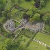 Oblique aerial view of the tower house with the gardens and stables adjacent, taken from the NE.