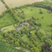 General oblique aerial view of the tower house with the gardens and stables adjacent, taken from the  NW.