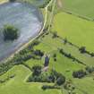 Oblique aerial view centred on the tower house with the remains of the motte (earthworks) adjacent, taken from the NE.