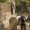 James Simpson examining wall on N side of cemetery