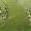 Oblique aerial view centred on the cropmarks of the unenclosed settlement, enclosure and rig, taken from the WNW.