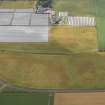 Oblique aerial view of the cropmarks of the rig and furrow, pits and unenclosed round houses at Hatton Farm, taken from the NE.