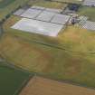 Oblique aerial view of the cropmarks of the rig and furrow, pits and unenclosed round houses at Hatton Farm, taken from the NNE.