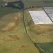 Oblique aerial view of the cropmarks of the rig and furrow, pits and unenclosed round houses at Hatton Farm, taken from the NNW.