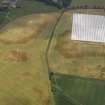 Oblique aerial view of the cropmarks of the rig and furrow, pits and unenclosed round houses at Hatton Farm, taken from the NW.