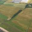 Oblique aerial view centred on the cropmarks of the rig and ring ditch with Hatton Country House beyond, taken from the ESE.