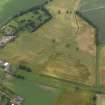Oblique aerial view of the cropmarks of the round houses, ring ditches and rig and furrow with Hedderwick House adjacent, taken from the NW.