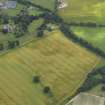 Oblique aerial view of the cropmarks of the buildings and rig and furrow with Lathrisk House adjacent, taken from the N.