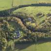 Oblique aerial view centred on the house with the stables adjacent, taken from the SW.