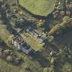 Oblique aerial view centred on the ruins of the country house with the stables adjacent, taken from the ENE.
