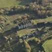 Oblique aerial view centred on the ruins of the country house with the stables adjacent, taken from the N.