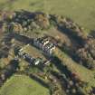 Oblique aerial view centred on the ruins of the country house with the stables adjacent, taken from the W.