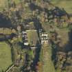 Oblique aerial view centred on the ruins of the country house with the stables adjacent, taken from the SW.