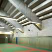 Interior. View of fitness studio showing exposed concrete structure of stadium grandstand.