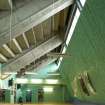 Interior. View of fitness studio showing exposed concrete structure of stadium grandstand.