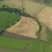 Oblique aerial view centred on the cropmarks of the souterrain, round houses and pits, taken from the SSW.