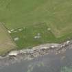 Oblique aerial view centred on the coastal gun battery with the remains of the broch adjacent, taken from the  NNE.